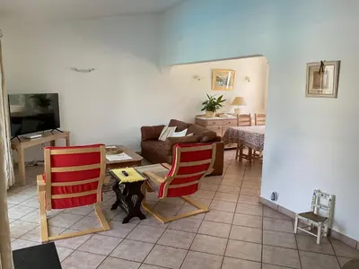 a living room with two red chairs and a couch at Casa Nicho in Vale do Lobo