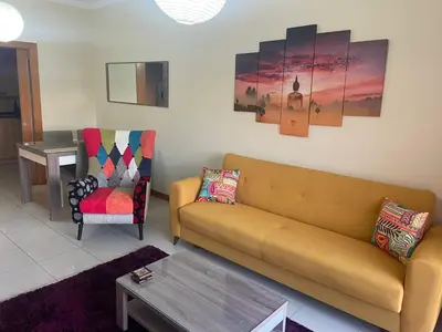 a living room with a couch and a chair at Quinta Barracuda Albufeira in Albufeira