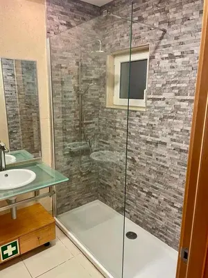 a bathroom with a glass shower with a sink at Quinta Barracuda Albufeira in Albufeira