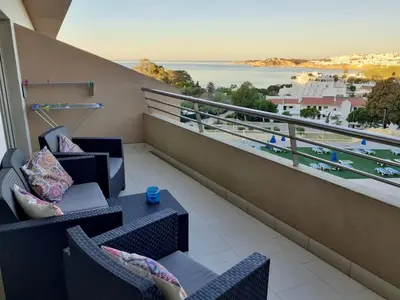 a balcony with chairs and a view of the water at Quinta Barracuda Albufeira in Albufeira