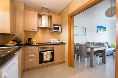 a kitchen with a table and a dining room at Quinta Barracuda Albufeira in Albufeira