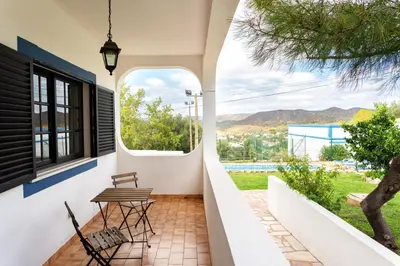 a patio with two chairs and a table and a window at Monte Madalena in Adega