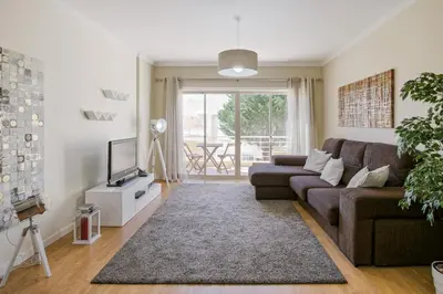 a living room with a couch and a tv at FLH Falésia Flat with Pool in Vilamoura
