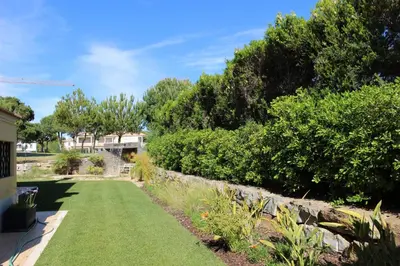 a garden with green grass and bushes and trees at VILLA SIBLING 2 in Vilamoura