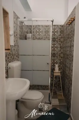 a bathroom with a toilet and a sink at Guest House Almeixar in Almancil