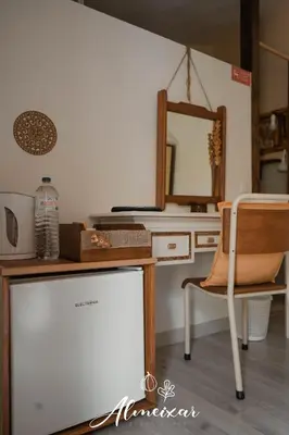 a desk with a mirror and a chair in a room at Guest House Almeixar in Almancil