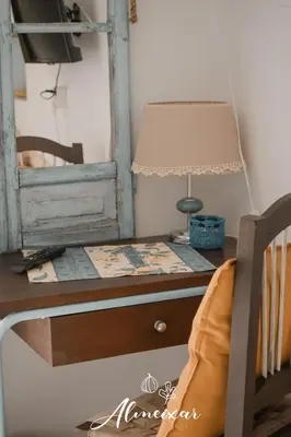 a desk with a lamp and a mirror at Guest House Almeixar in Almancil