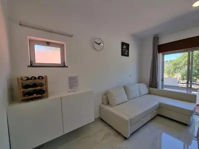 a white living room with a couch and a window at AAA Apartments in Albufeira