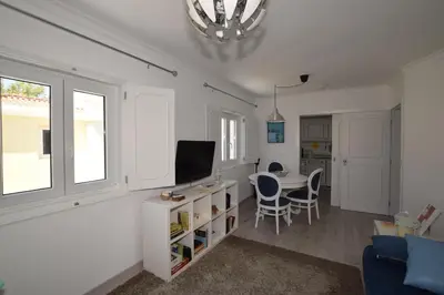 a living room with a tv and a table with chairs at Irene's Place Marina in Quarteira