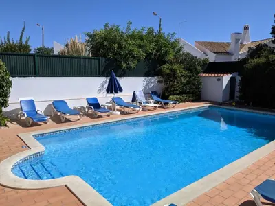 a swimming pool with lounge chairs and a swimming pool at CASA MALINDI in Albufeira