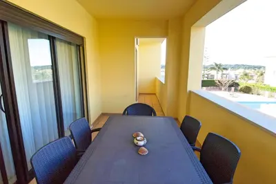 a table and chairs in a room with a large window at Vilamoura Condominio do Pinhal in Vilamoura