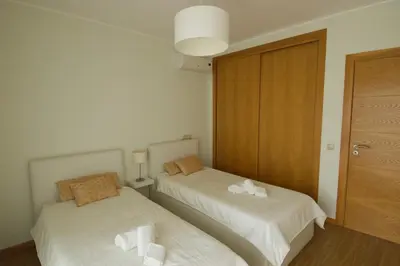 a room with two beds with towels on them at Vilamoura Condominio do Pinhal in Vilamoura