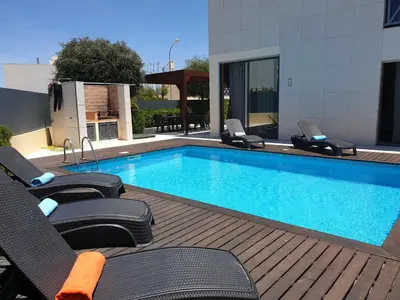 a swimming pool with two chairs and a swimming pool at Albufeira Oura Beach V4 Villa Marisa with private Pool in Albufeira