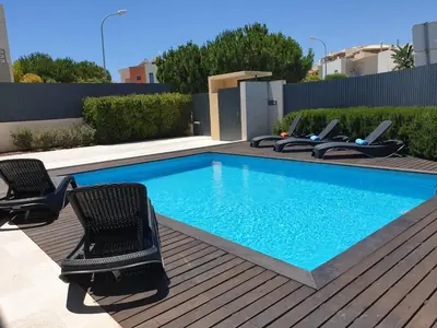 a swimming pool with two chairs at Albufeira Oura Beach V4 Villa Marisa with private Pool in Albufeira