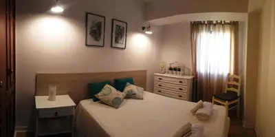 a small bedroom with a bed and a dresser at Casa dos Teixeiras in Quarteira