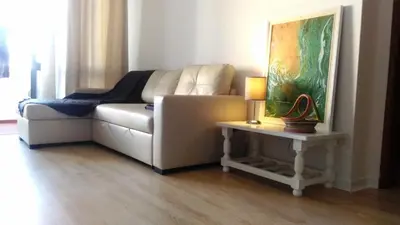 a living room with a couch and a table with a lamp at Casa dos Teixeiras in Quarteira