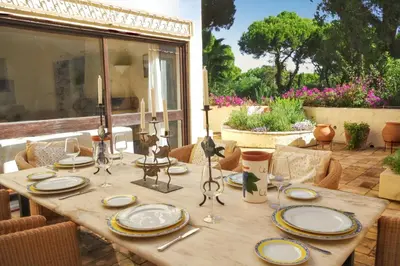 a wooden table with plates on top of it at Elegant Villa in Vilamoura with Private Pool in Vilamoura