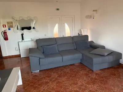 a living room with a gray couch in a room at Quinta das Nespereiras in Patã de Cima