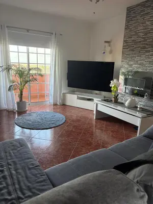 a living room with a couch and a flat screen tv at Quinta das Nespereiras in Patã de Cima