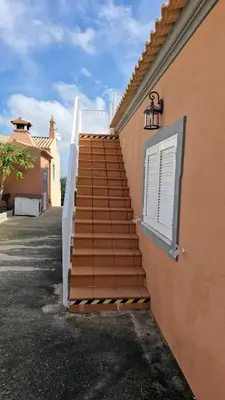 a set of stairs next to a building with a window at Quinta das Nespereiras in Patã de Cima