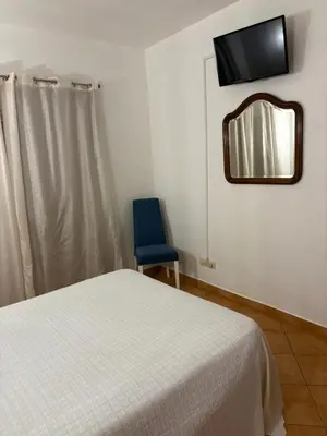 a bedroom with a bed and a mirror and a blue chair at Quinta das Nespereiras in Patã de Cima