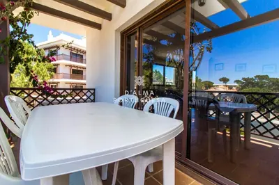 a white table and chairs on the balcony of a house at D'Alma Falésia Beach Apartment - By Dalma Portuguesa in Albufeira