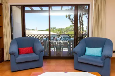 two blue chairs in a living room with a balcony at D'Alma Falésia Beach Apartment - By Dalma Portuguesa in Albufeira