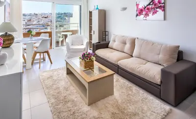 a living room with a couch and a table at Apartamentos Mónaco by Garvetur in Albufeira