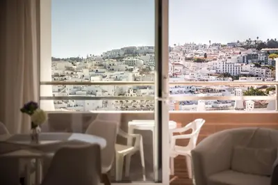a room with a view of a city through a window at Apartamentos Mónaco by Garvetur in Albufeira
