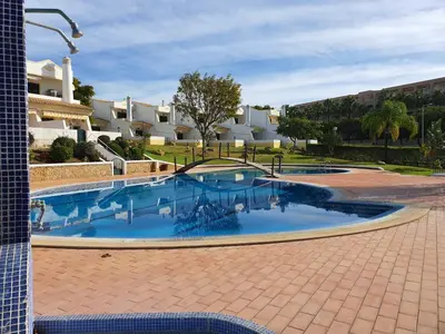 a large swimming pool in a courtyard with buildings at Villa Martina - São Rafael - Albufeira in Albufeira