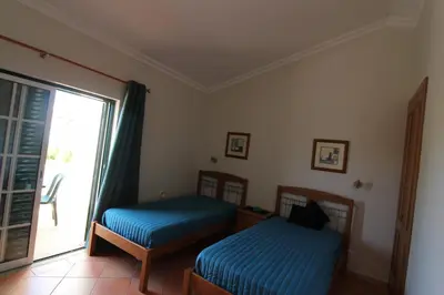 a bedroom with two beds and a large window at Villa Martina - São Rafael - Albufeira in Albufeira