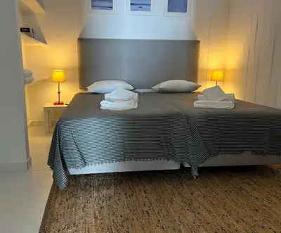 a bedroom with a bed with two towels on it at Pine House - Faro Airport, Beach and City Center in Faro