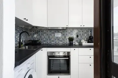 a kitchen with white cabinets and a sink and a dishwasher at Marina Club - Sea front - Vilamoura in Vilamoura