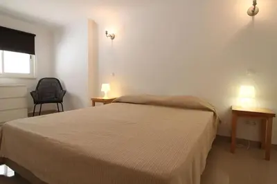 a bedroom with a bed and two tables and two lamps at Lotus Villa V5 com piscina comum - Boliqueime, Algarve in Boliqueime