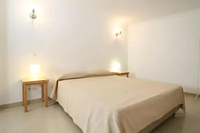 a bedroom with a bed and two tables with lamps at Lotus Villa V5 com piscina comum - Boliqueime, Algarve in Boliqueime