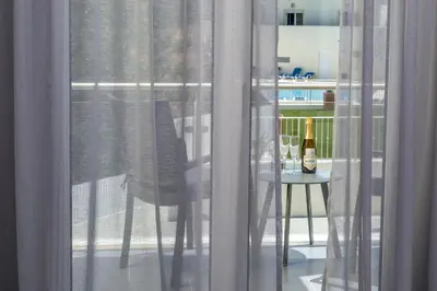 a glass window with a bottle of wine on a table at D_Loft Ocean in Albufeira