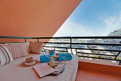 a bed on a balcony with a view of a city at Marina Princess in Vilamoura