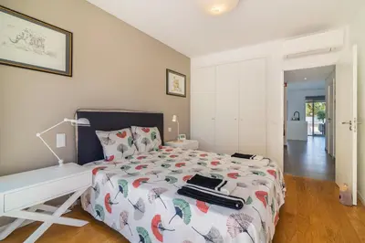 a white bedroom with a bed and a desk at Garden Design in Albufeira