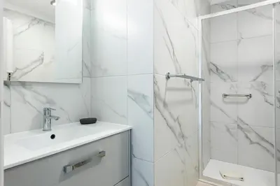 a white bathroom with a sink and a shower at Moura Suites III - Relaxing view - Vilamoura HD Properties in Vilamoura
