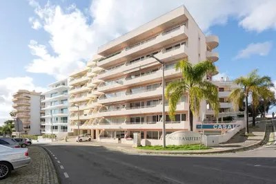 a large white apartment building with a palm tree at Moura Suites III - Relaxing view - Vilamoura HD Properties in Vilamoura