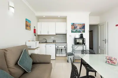 a kitchen and living room with a couch and a table at Moura Suites III - Relaxing view - Vilamoura HD Properties in Vilamoura