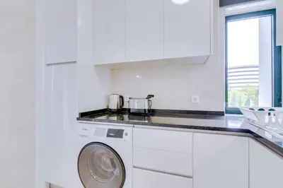 a white kitchen with a washing machine in it at Tália I - City Center - Vilamoura in Vilamoura