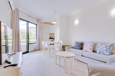 a living room with a couch and a table at Tália I - City Center - Vilamoura in Vilamoura