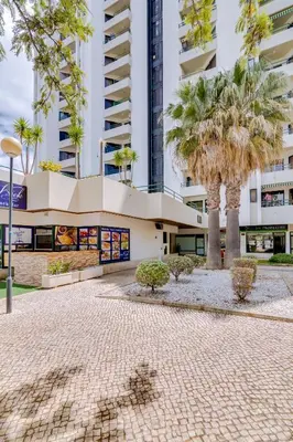 a building with palm trees in front of it at Tália I - City Center - Vilamoura in Vilamoura