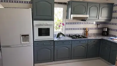 a kitchen with green cabinets and a white refrigerator at Villa Navita in Loulé