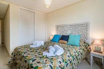 a bedroom with a bed with towels on it at CAROB APARTMENT - BY MAYORAL (FALÉSIA BEACH) in Olhos de Água
