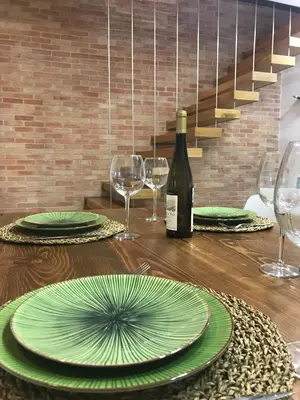 a table with green plates and a bottle of wine at Porta 20 in Loulé