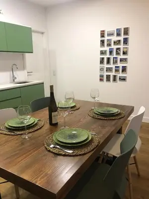 a wooden table with green plates and wine glasses at Porta 20 in Loulé