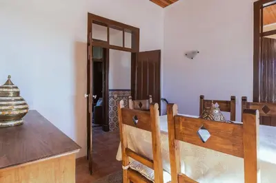 a dining room with a wooden table and chairs at Solar da Rosa & Solar da Tirosa in Boliqueime