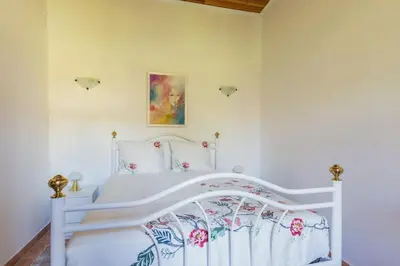 a bedroom with a white bed with flowers on it at Solar da Rosa & Solar da Tirosa in Boliqueime